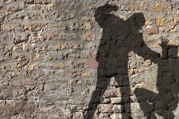 shadow on wall of a person about to hit another person